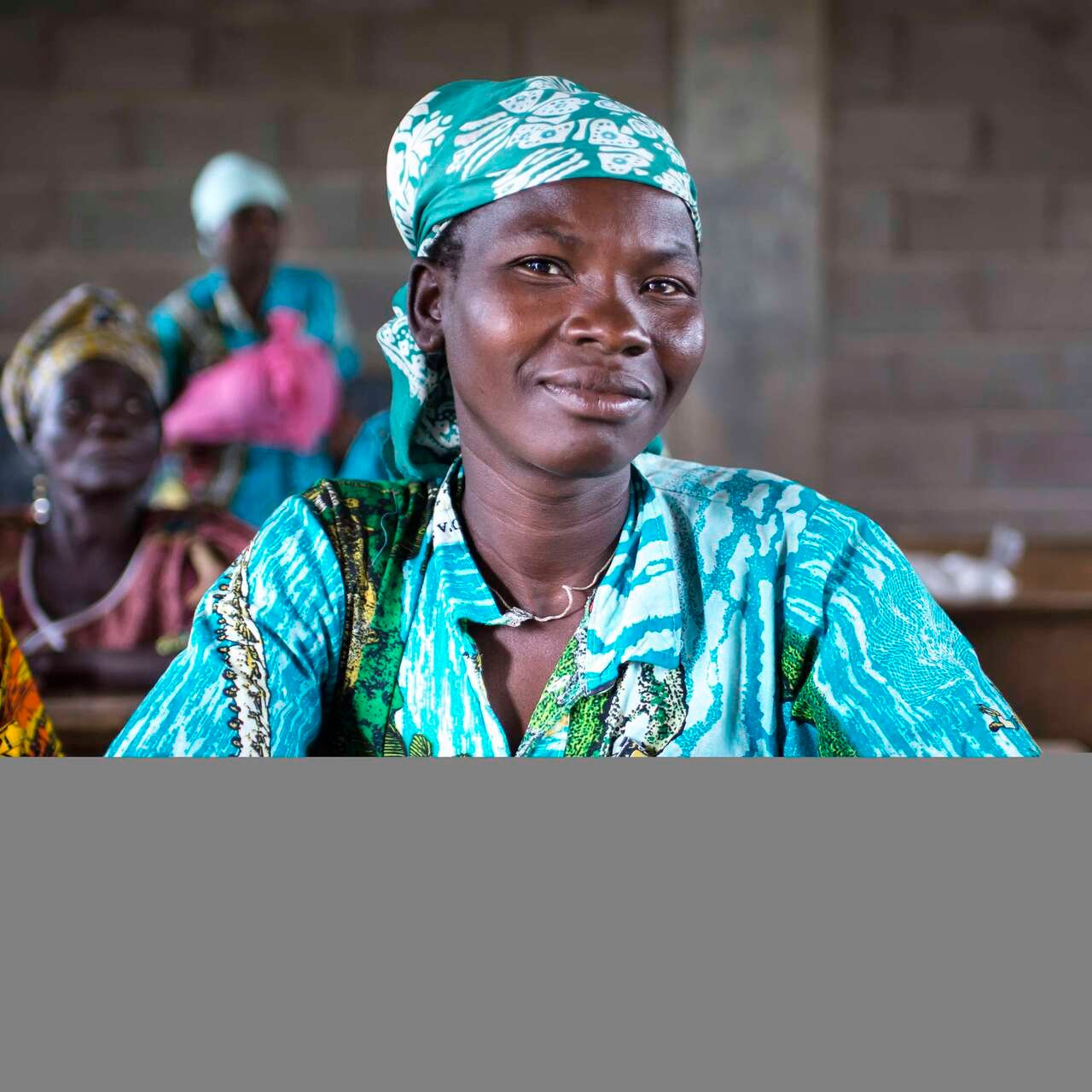 Teilnehmerin eines Workshops für Mitglieder*innen eines Frauenverbandes in Ngoutere, Zentralafrikanische Republik sitzt am Tisch.