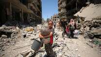 A Palestinian girl walks through a devastated street in Gaza.