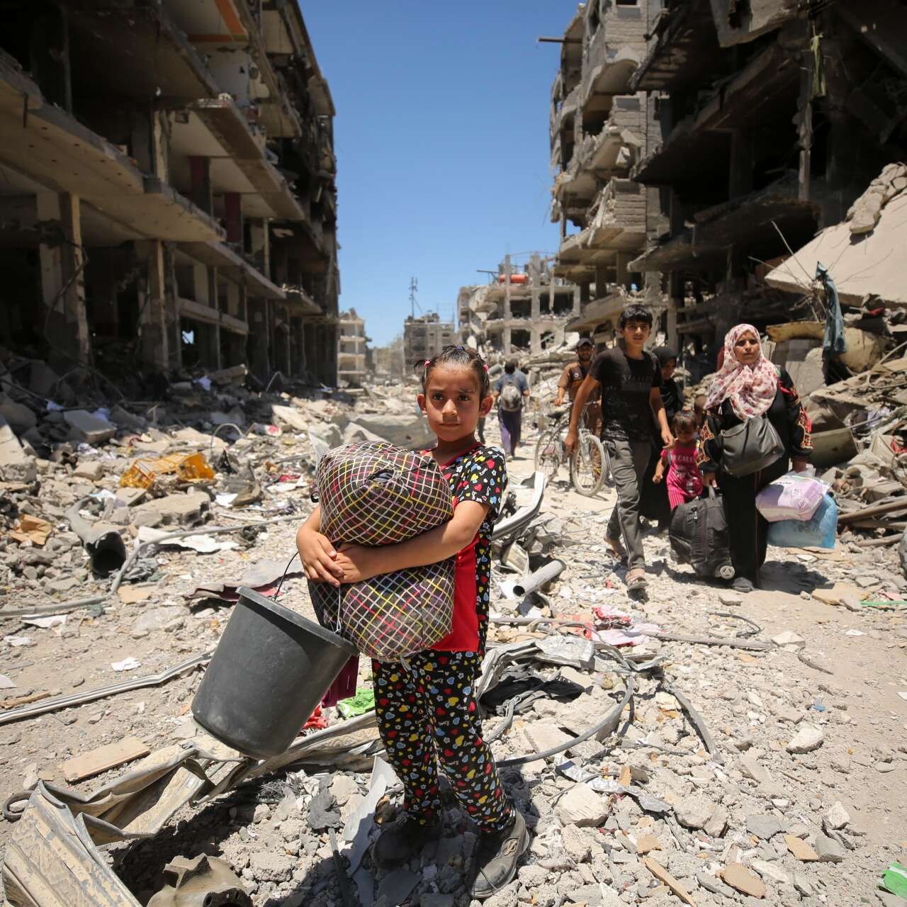 A Palestinian girl walks through a devastated street in Gaza.